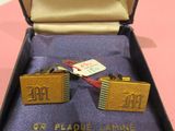 a pair of cufflinks in a box on a table