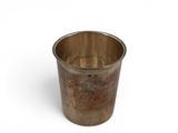 a metal cup that is sitting on a white surface