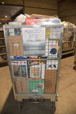 un chariot métallique chargé de nombreux objets dans un entrepôt