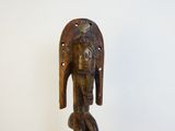 une image représentant une statue en bois d'une femme portant une coiffe