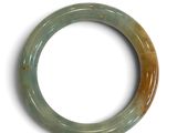 une photo d'un bracelet en jade vert posé sur une surface blanche