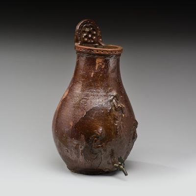 une image représentant un vase marron sur lequel est posé un oiseau