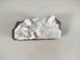 a small piece of rock with white crystals on it