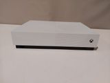 a close up of a white xbox one sitting on top of a table