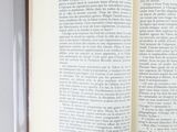 an open book sitting on top of a table next to a cup of coffee