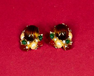 two pairs of earrings on a red surface with a red background