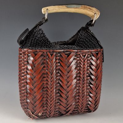 a brown woven bag with a wooden handle and handles
