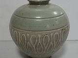 a green vase sitting on top of a white table