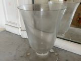 a glass vase sitting on a counter in front of a mirror
