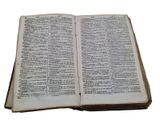 an old open book sitting on top of a white surface