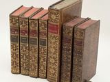 plusieurs vieux livres posés les uns sur les autres sur une surface blanche