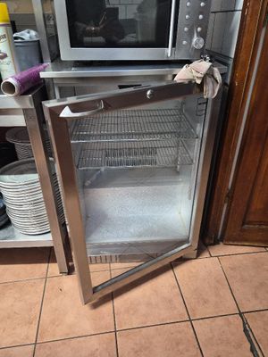 a microwave sitting inside of a glass door in a kitchen
