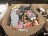 une boîte en carton remplie d'objets hétéroclites sur le sol