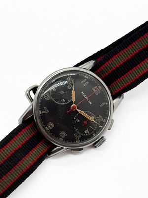 a watch with a black face and a red and green band