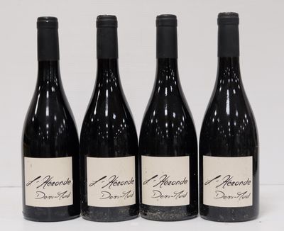 four bottles of wine are lined up on a white surface
