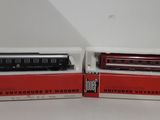two red and black train cars sitting next to each other on a table