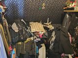 une armoire remplie de vêtements et d'autres objets dans la pièce