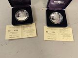 two silver coins are in a blue box on a table