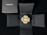 a black box with a gold brooch on top of it