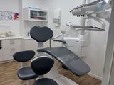an image of a dentist ' s office with a chair and dental equipment