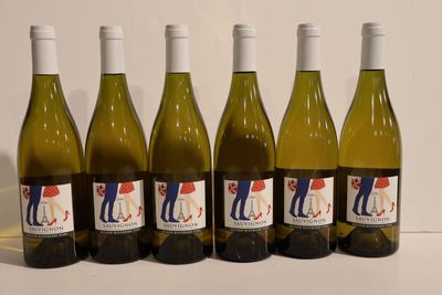six bottles of white wine are lined up on a table