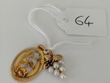 a close up of a gold and pearl necklace with a tag on it