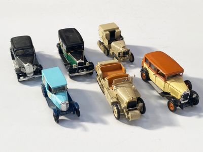 plusieurs petites voitures sont alignées sur une surface blanche