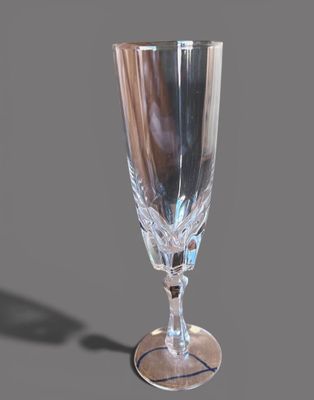 un verre posé sur une table, sur laquelle il projette une ombre