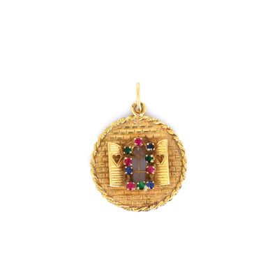 a close up of a gold pendant with a cross on it
