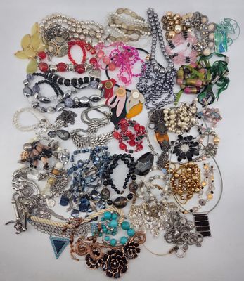 a pile of assorted jewelry on a white surface