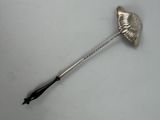 a silver spoon with a black handle on a white surface