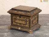 une petite boîte en bois avec un couvercle en métal, posée sur une table