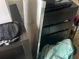 a microwave sitting on top of a cabinet next to a trash can