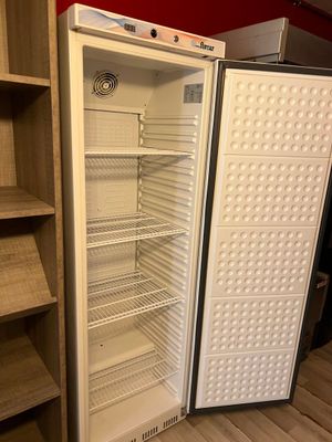 an empty refrigerator in the corner of a room