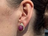a close up of a woman ' s ear wearing a pair of earrings