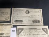 three old french currency notes are on a black table
