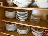 many plates and bowls on the shelves in the kitchen
