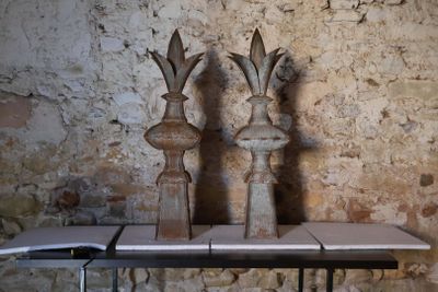 trois vases posés sur une table devant un mur de briques