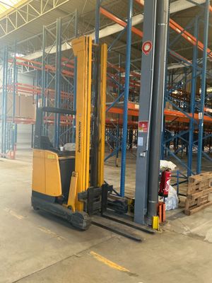 a forklift in a warehouse with pallets and boxes