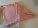 a folded pink cloth sitting in a box on a table