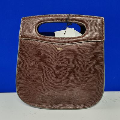 une photo d'un sac à main marron posé sur une table