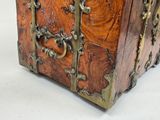 a small wooden chest with metal handles on a white surface