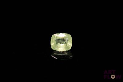 a yellow diamond on a black surface with a black background