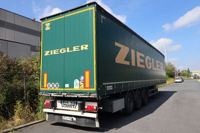 a green semi truck that is parked on the side of the road