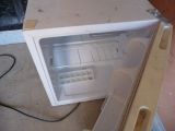 a small white microwave sitting on the floor in the kitchen