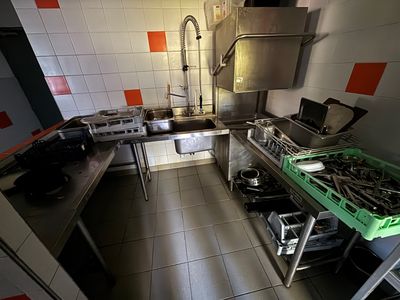 une photo d'une cuisine avec une cuisinière, un évier et une plaque de cuisson
