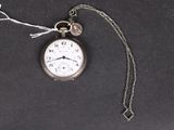 une montre à gousset en argent à laquelle est attachée une chaîne