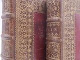 two old books sitting on top of each other on a table