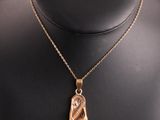 un collier plaqué or avec un pendentif en forme de feuille sur un mannequin