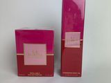 a pair of pink perfume bottles sitting on top of a white surface